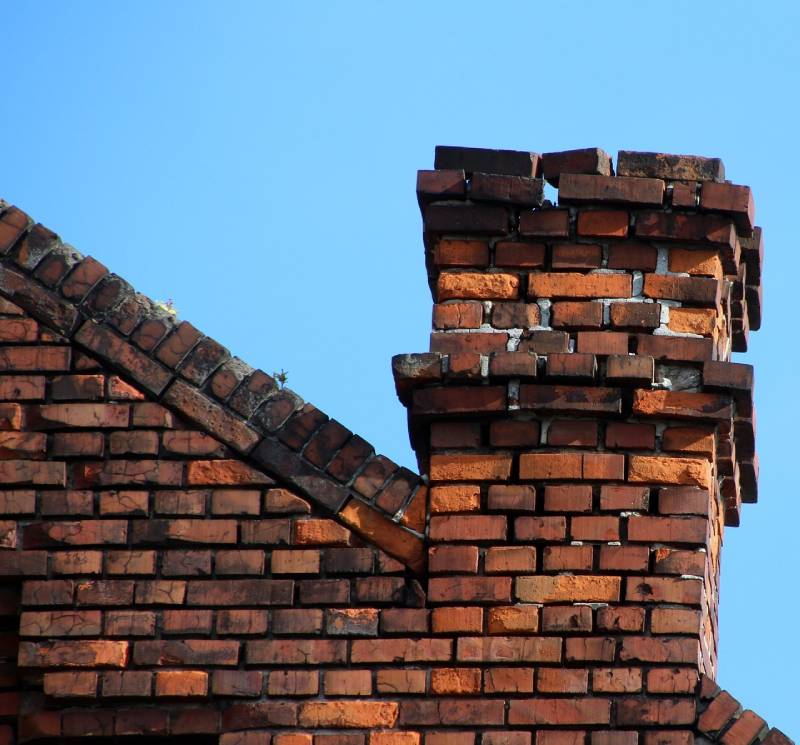 Damaged chimney on an Annapolis home showing cracks and missing mortar